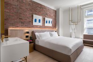 a bedroom with a large bed and a brick wall at Gladstone House in Toronto