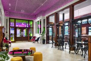 a restaurant with purple ceilings and tables and chairs at Gladstone House in Toronto