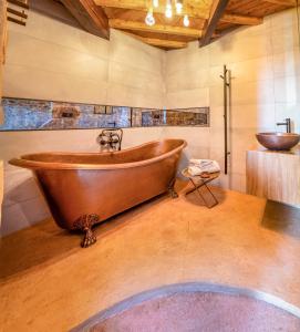 La salle de bains est pourvue d'une baignoire en cuivre et d'un lavabo. dans l'établissement L'Olivier Loft HH Centre Corum - Netflix & Prime Video 4k, à Montpellier