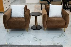 2 sillas y una mesa en una habitación con suelo de mármol en Kay's Comfort Place en Lekki