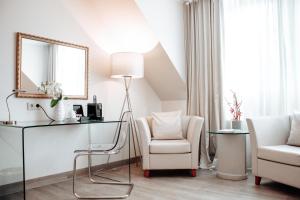 a living room with a desk and a chair and a mirror at Clostermanns Hof in Niederkassel