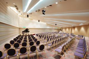 an empty auditorium with chairs and a grand piano at Bellino Hotel Ichinoseki in Ichinoseki