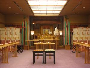 a dressing room with tables and benches and a mirror at Bellino Hotel Ichinoseki in Ichinoseki