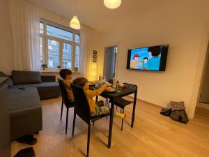 twee kinderen zitten aan een tafel in een woonkamer bij Residence Neverin Trieste in Trieste