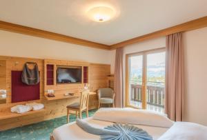 una camera d'albergo con due letti e una televisione di Hotel Berghof a Ramsau am Dachstein