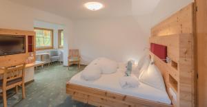 una stanza con un letto, una scrivania e una televisione di Hotel Berghof a Ramsau am Dachstein Altre 29 foto