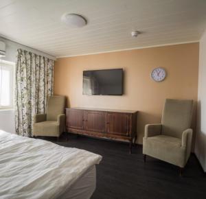 una camera con un letto, due sedie e una TV di Bed and Breakfast Artjärvi ad Artjärvi