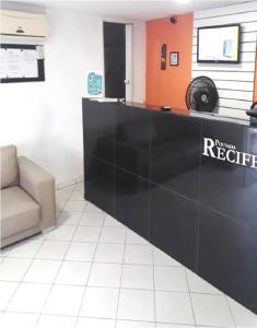 a black reception counter in a room with a chair at Pousada Recife Inn in Recife