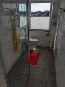 La salle de bains est pourvue d'un lavabo, de toilettes et d'une fenêtre. dans l'établissement Apartment 31K, à Castrop-Rauxel