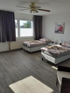 Cette chambre comprend 3 lits et un ventilateur de plafond. dans l'établissement Apartment 31K, à Castrop-Rauxel