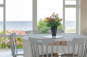 a white table with a vase of flowers on it at Dolphin Watch Wild Atlantic Way in Fanore