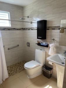 a bathroom with a toilet a sink and a bath tub at Ulala Culebra in Culebra
