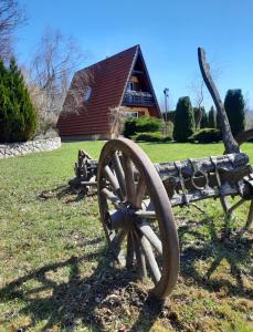 a statue of a wooden wagon in front of a house at Planinska kuca Dasovic in Fužine