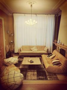 a living room with a couch and a table at karaktervolle woning met zwembad te Ronse in Ronse