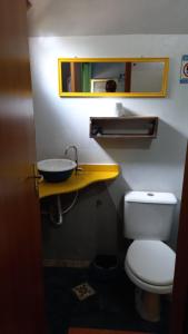 uma casa de banho com um WC branco e um lavatório. em Complexo Halley em Lençóis