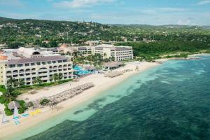 - une vue aérienne sur une plage avec des bâtiments et l'océan dans l'établissement Iberostar Grand Rose Hall, à Montego Bay