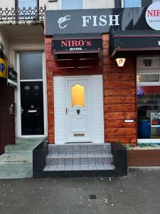 a building with a white door with a sign on it at NIRO's Hotel in Blackpool