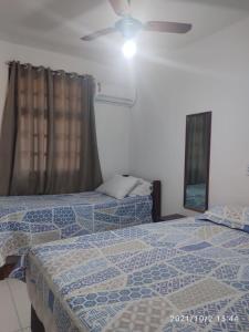 1 Schlafzimmer mit 2 Betten und einem Deckenventilator in der Unterkunft Apartamento Taperapuan in Porto Seguro