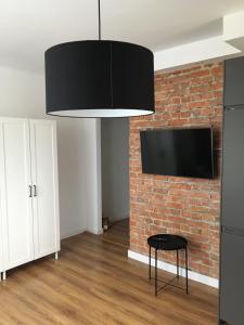 a living room with a brick wall and a black chair at Koszalin-Old Town Apartment in Koszalin