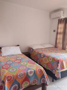 a room with two beds and a bedspread on it at Apartamento Taperapuan in Porto Seguro