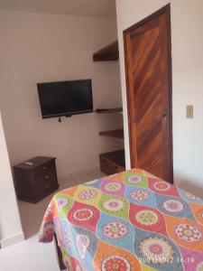 1 dormitorio con 1 cama y TV de pantalla plana en Apartamento Taperapuan, en Porto Seguro