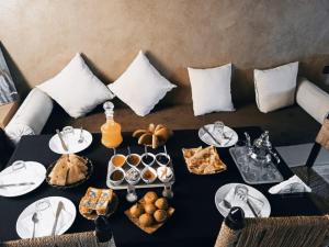 una mesa con comida y platos en un sofá en L'homme Du Désert A Merzouga en Merzouga