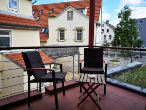 2 sillas y una mesa en el balcón en beliebtes City-Apartment Reutlingen en Reutlingen