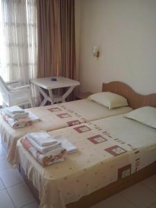 um quarto com 2 camas, toalhas e uma mesa em Guest House Preslav em Nessebar