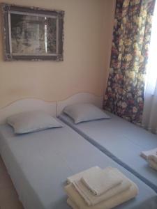 two twin beds in a room with towels on them at Guest House Preslav in Nesebar