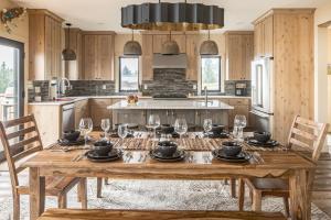 uma cozinha com uma mesa de madeira e copos de vinho em Big Pine Chalet em Big Sky