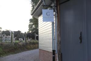 una señal en el costado de un edificio con vacas en un campo en "Chez Michel " Les Gîtes de Séry en Bouillancourt-en-Séry