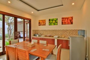 uma sala de jantar com uma mesa e uma cozinha em Villa Anandani em Ubud