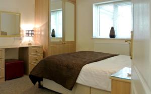 a bedroom with a bed and a desk and a mirror at Wortley House Hotel in Scunthorpe