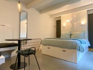 een slaapkamer met een bed, een stoel en een tafel bij B&B 't Gasthuysje in Dokkum