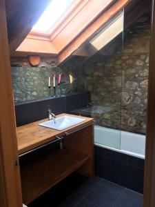 y baño con lavabo y ducha. en Casa de poble acollidora,amb llar de foc, traster en Bourg-Madame