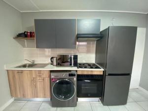 a kitchen with a refrigerator and a washing machine at Insaka's Greenlee 3 Luxurious Apartment in Avalon