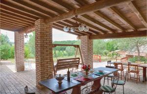 eine Terrasse mit einem Tisch und Stühlen sowie einer Holzdecke in der Unterkunft Nice Home In Montefiascone Vt With Private Swimming Pool, Can Be Inside Or Outside in Ranucci