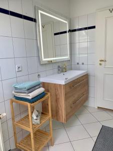 Charmante Dachgeschoss Wohnung في لايبزيغ: حمام مع حوض ومرآة