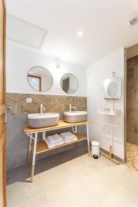 a bathroom with two sinks and two mirrors at La Maison du Grand Bossieu in Bossieu