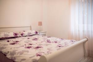 Un dormitorio con una cama con flores púrpuras. en Căsuța din Copou en Iaşi