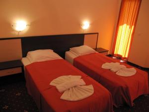 duas camas num quarto de hotel com toalhas em Maverick Hotel em Sunny Beach