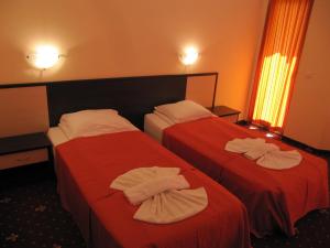 zwei Betten in einem Hotelzimmer mit Handtüchern darauf in der Unterkunft Maverick Hotel in Sonnenstrand + 25 Fotos