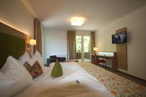 ein Hotelzimmer mit einem großen Bett und einem Schreibtisch in der Unterkunft Hotel Aberseehof in Sankt Gilgen