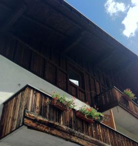 a wooden balcony with potted plants on a building at Flurahof in Martello