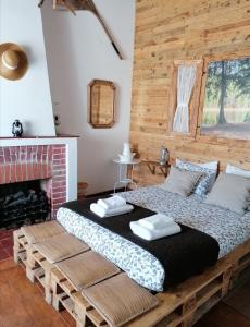 a bed in a room with a brick fireplace at Santa Maria do Mar Guest House in Peniche