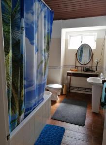 a bathroom with a toilet and a shower curtain at Santa Maria do Mar Guest House in Peniche