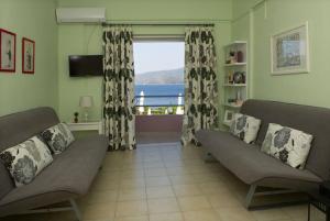 una sala de estar con 2 sofás y una ventana grande en Mirella Studios, en Loutra Oraias Elenis