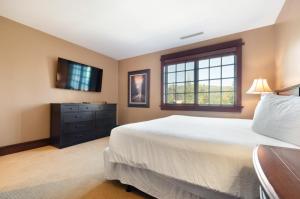 a bedroom with a bed and a dresser and a window at Arrowleaf Lodge - 1 Bed Studio #111B in Park City