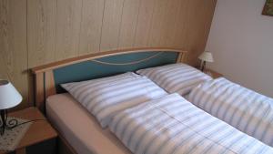 ein Bett mit zwei Kissen auf einem Zimmer in der Unterkunft Blasbichler Appartments in Bruneck