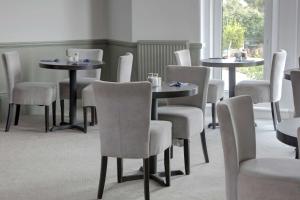 a dining room with two tables and chairs at Exmouth Beach Hotel in Exmouth +23 photos